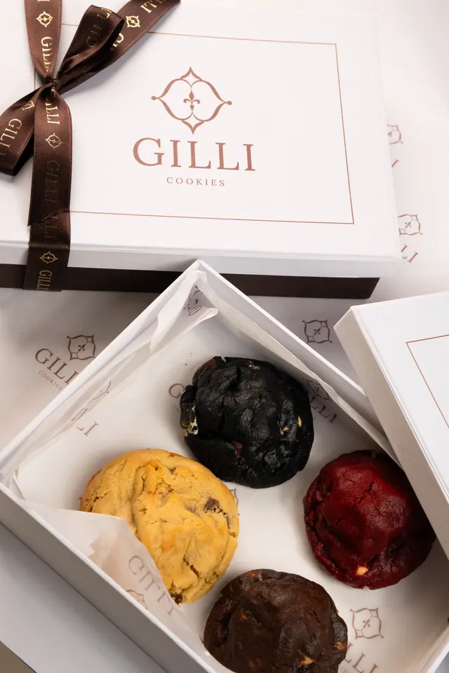Caixa Gilli aberta com quatro cookies: dark, red velvet, tradicional e GL