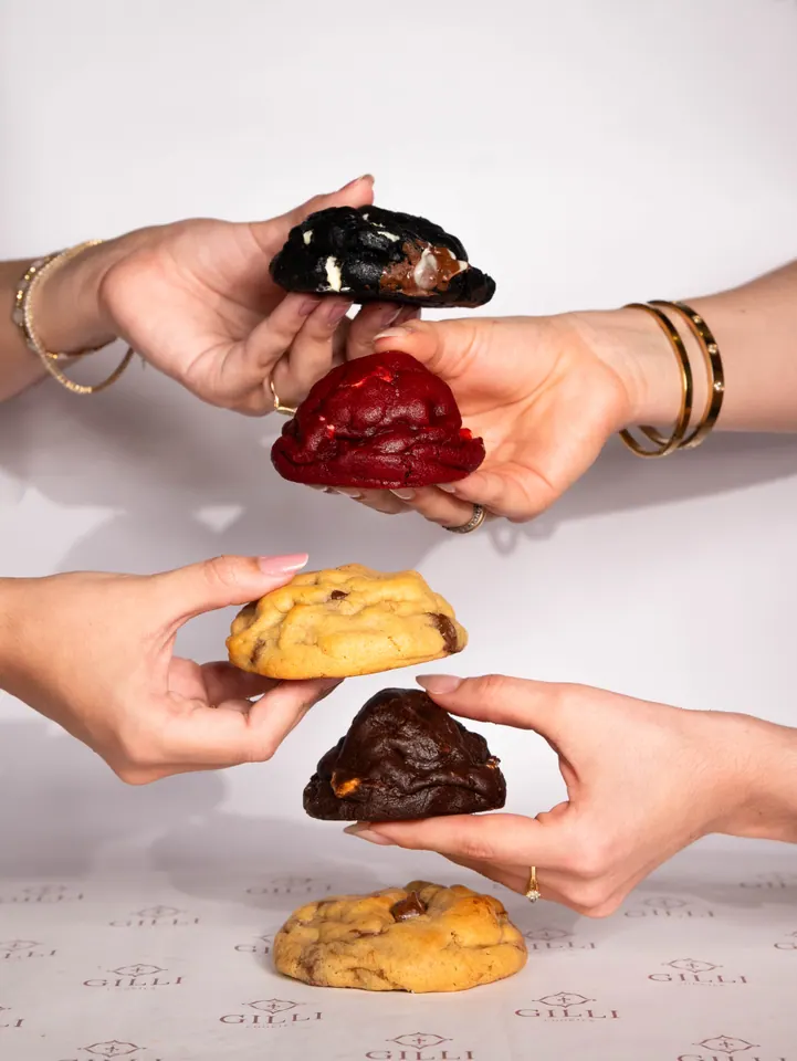 Mãos passando cookies de quatro sabores diferentes